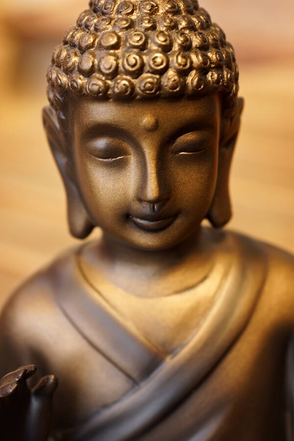 Buddha-Figur aus Bronze mit geschlossenen Augen und sanftem Lächeln