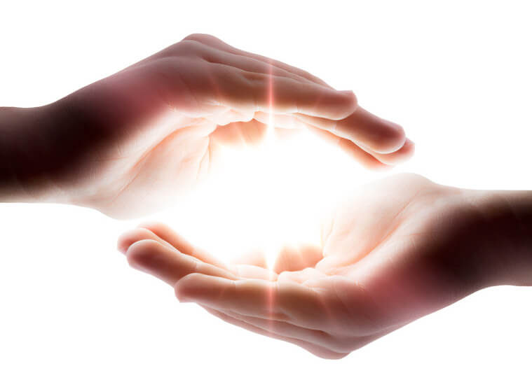Zwei Hände mit Licht dazwischen als Symbol für Reiki-Energie