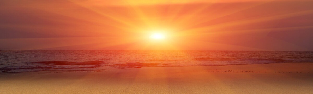 Sonnenuntergang am Strand mit warmen Strahlen über dem Meer